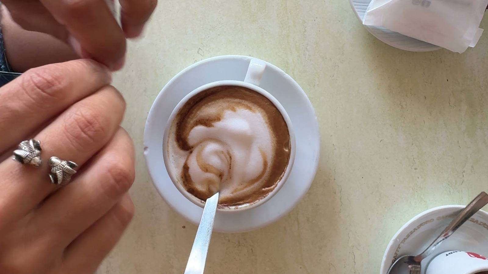 Tipping in Italy &mdash; a cappuccino on an Italian caf&eacute; table